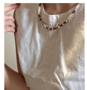 Detail of beaded S925 silver necklace with brown sandstone and white natural stones