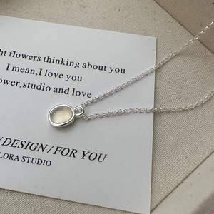 Elegant S925 silver necklace with oval white gemstone pendant on a poetic card backdrop