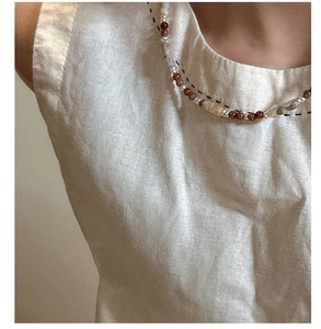 Close-up of S925 silver beaded necklace with brown goldstone and marbled cylindrical beads