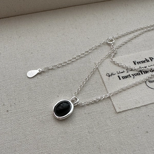 Minimalist S925 sterling silver necklace with oval black agate pendant on linen fabric
