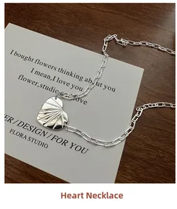 Détail du collier cœur en argent s925 avec texture soleil sur une carte blanche