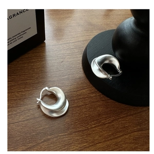 Detailed macro view of S925 sterling silver earrings with matte brushed texture and U-shape