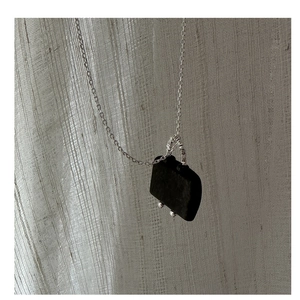 Detailed close-up of a stylish S925 silver necklace with a black handbag-shaped pendant