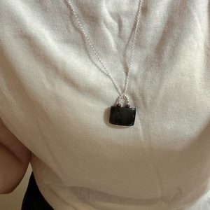 Minimalist S925 silver necklace featuring a black handbag-shaped pendant on a model