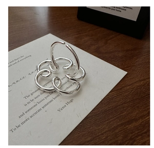 Dettaglio macro dell'anello a fiore a spirale in argento sterling S925 su carta artistica