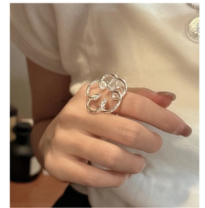 Dettaglio dell'anello a fiore in argento S925 con design traforato indossato a mano