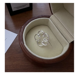 Dettaglio dell'anello a fiore traforato in argento S925 lucido su astuccio in velluto