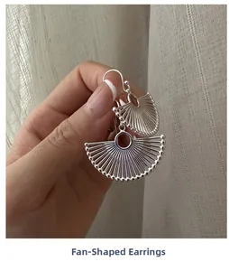 Detailed close-up of hollowed fan-shaped S925 sterling silver drop earrings with bead edge