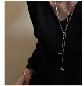 Detail of S925 silver Y-shaped long necklace with minimalist T-bar pendant in gold and silver