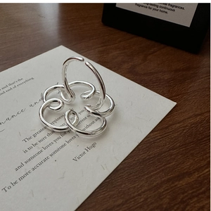 Dettaglio artistico di un anello a spirale in argento su un biglietto con citazione