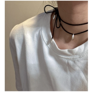 Detail der silbernen Wassertropfen-Anhänger an einem minimalistischen schwarzen Choker