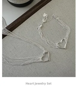 Detail view of multi-strand silver necklace set with minimalist hollow heart pendant