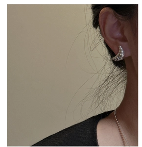 Close-up of S925 sterling silver croissant hoop earrings on model ear lobe