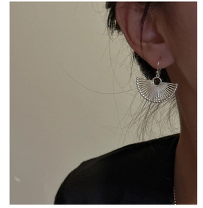 Macro shot of silver fan-shaped earrings with a central black gemstone insert