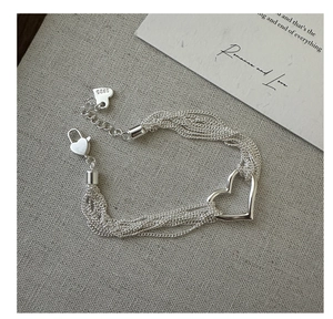 Detail of S925 sterling silver multi-strand chain bracelet with a hollow heart charm