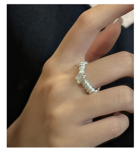 Nahaufnahme eines gedrehten S925 Silberrings mit rechteckigem Zirkonia am Finger eines Models