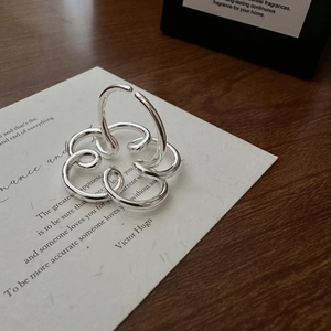 Anello d'argento a strati artistico con design floreale astratto su carta minimalista