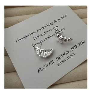Close-up of S925 sterling silver croissant stud earrings with polished texture