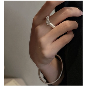 Detail eines S925 Silberrings mit Textur und passendem minimalistischem Armreif