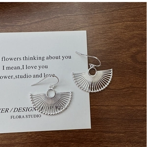 Macro detail of S925 sterling silver fan-shaped earrings with delicate beaded edge finish