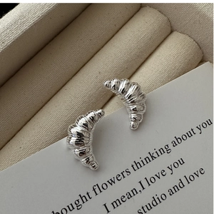 Macro shot of S925 sterling silver croissant stud earrings with fine spiral texture