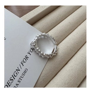 Makroaufnahme von silbernem strukturiertem offenem Ring mit Zirkonia-Akzenten