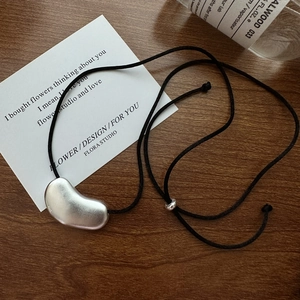 Minimalist S925 sterling silver bean pendant with matte finish on black wax rope cord