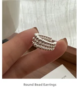 Gros plan détaillé de boucles d'oreilles clips multi-rangs en perles argentées à la main