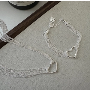 Detailed close-up of multilayer silver heart necklace with delicate polished links