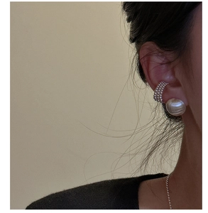 Gros plan d'une manchette d'oreille en argent S925 et d'un clou rond portés par un mannequin