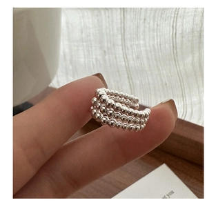 Gros plan d'une manchette d'oreille multicouche en argent à perles sur fond neutre