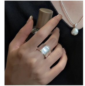 Detail of S925 sterling silver matte wide ring with irregular texture on model hand