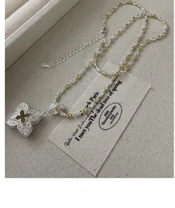 Macro detail of S925 sterling silver clover pendant with intricate gold arabesque patterns
