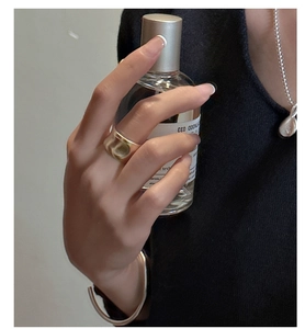 Detailed view of wide golden matte ripple ring with brushed texture on female hand