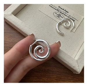 Detail of S925 sterling silver spiral hoop earrings with sleek twisted metal design