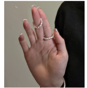 Macro detail of silver S925 rings featuring modern twisted texture on model's hand