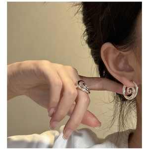 Detail of silver spiral ring and earring set on model with a polished mirror finish
