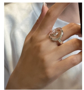 Close-up of minimalist S925 sterling silver ring with unique 3D spiral design on finger