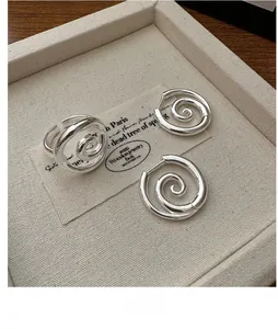 Detailed close-up of S925 sterling silver spiral ring and earrings set on jewelry tray