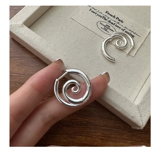 Close-up of S925 sterling silver spiral hoop earrings with polished mirror finish