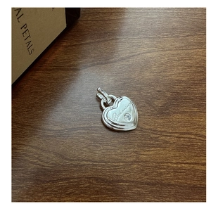 Détail du pendentif cœur en argent S925 avec gravure Beckoning et zircon sur bois