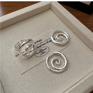 Macro detail of S925 sterling silver ring and earrings set with spiral twist design