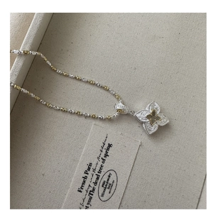 Macro detail of S925 silver four-leaf clover pendant with vintage engraved texture