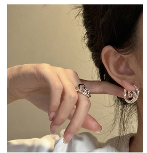 Close-up of minimalist S925 sterling silver spiral ring and matching earring set on model
