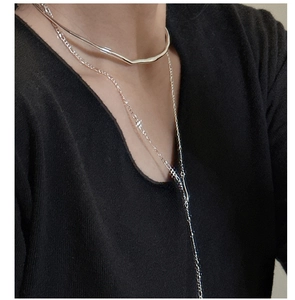 Detail of layered S925 silver choker and long chain necklace on female neck