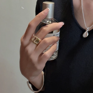 Artistic matte silver wide band ring with brushed texture on a model's finger