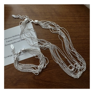 Detail of S925 sterling silver multilayer beaded bracelet and necklace set on wood