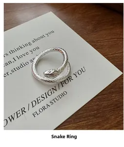 Macro shot of silver S925 snake ring with scale textures on a white display card