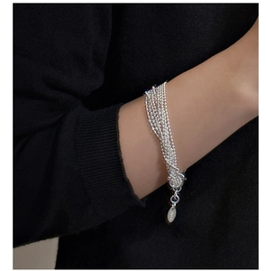 Detail of multi-strand S925 sterling silver beaded bracelet on a dark knit background