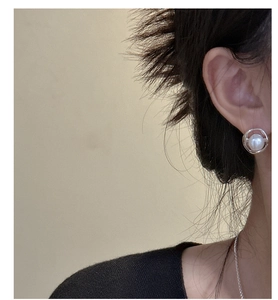 Close-up of minimalist S925 silver earring with a white pearl on a female model